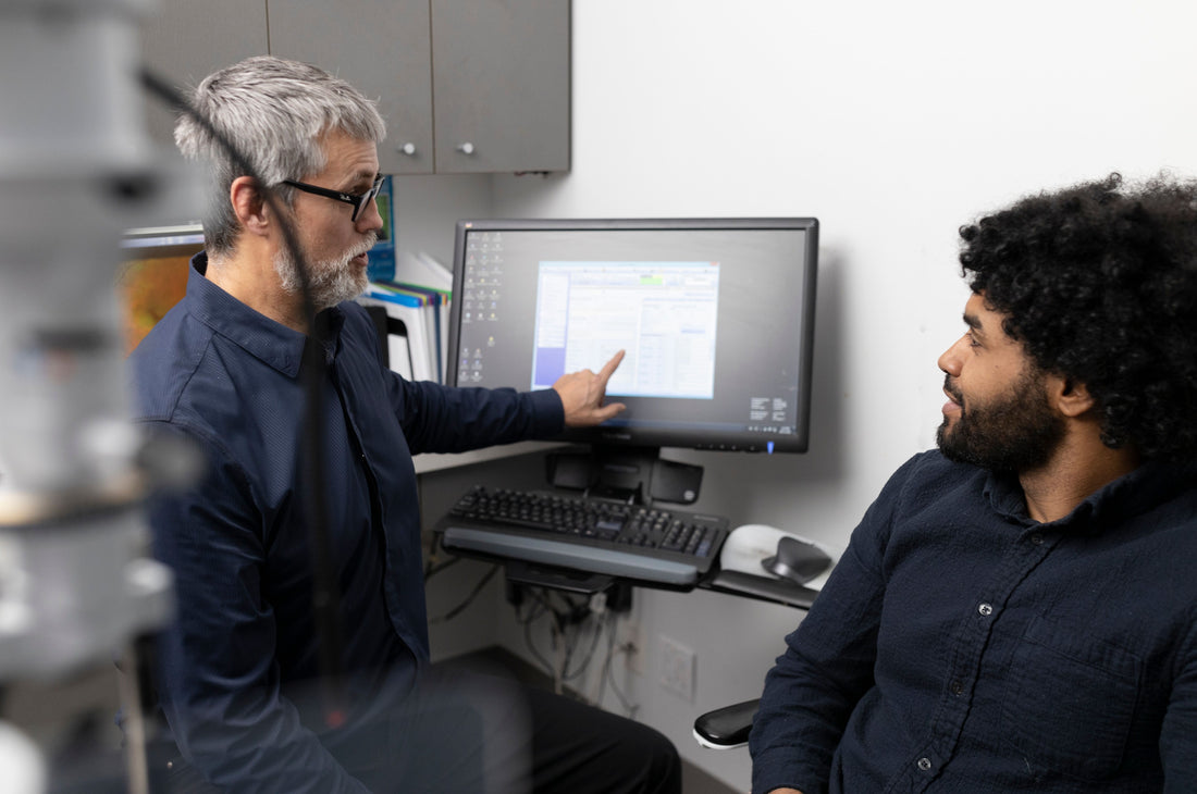 An eye doctor explaining laser eye surgery to a patient using technology