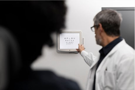 An optometrist conducting a nearsightedness test on a patient using eye technology