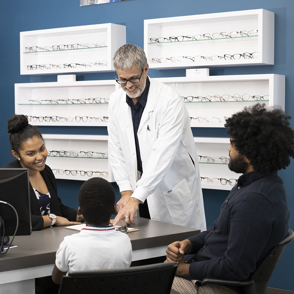 An optometrist happily attending to a family in need of eye care services