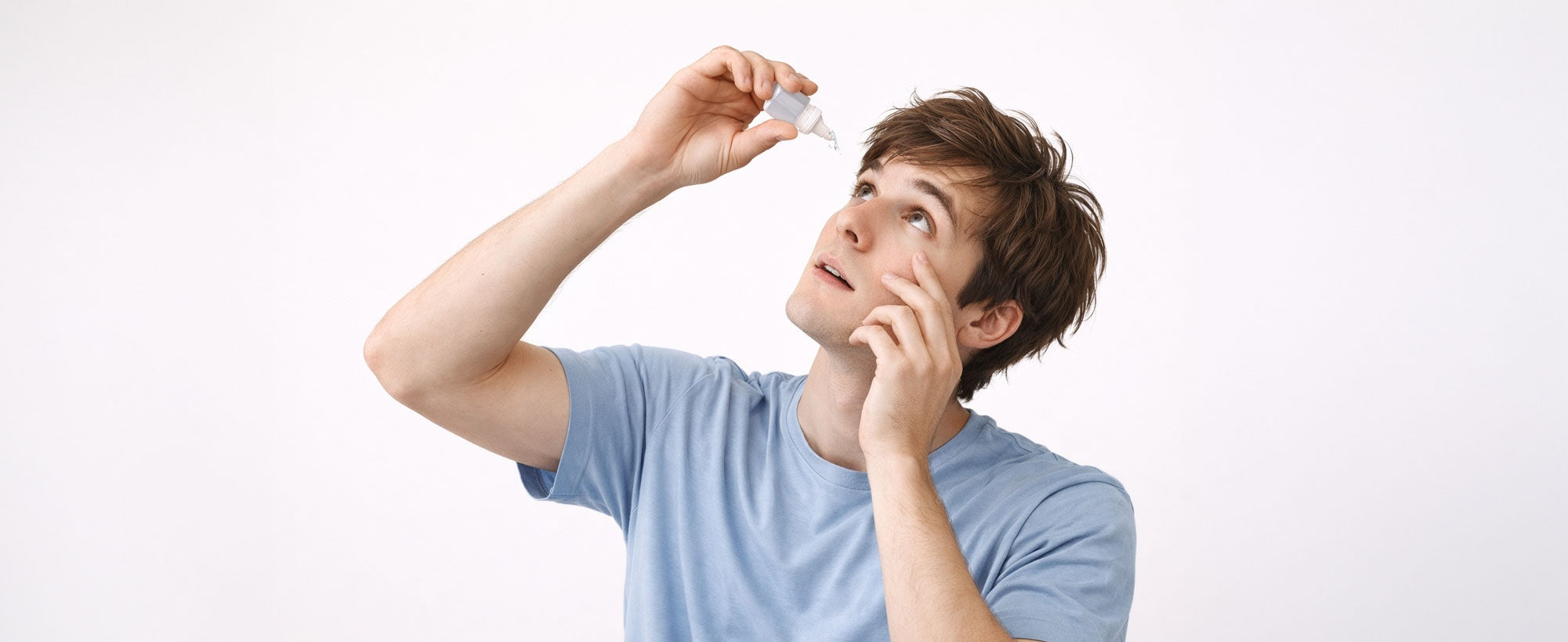 Young man using eye drops