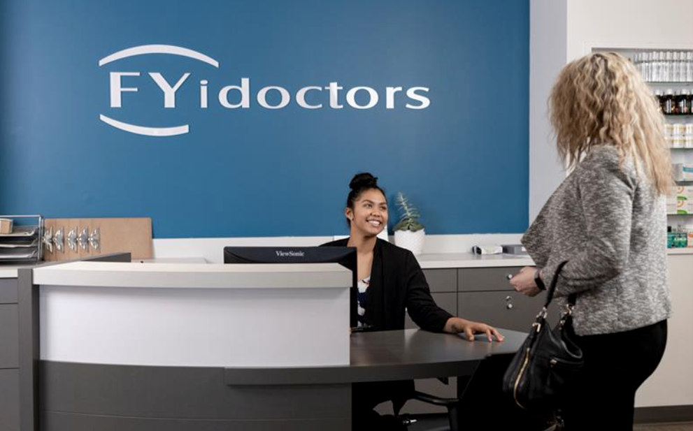 An FYidoctor receptionist warmly responding to a walk-in customer with a smile at one of the Fyidoctors eye clinics