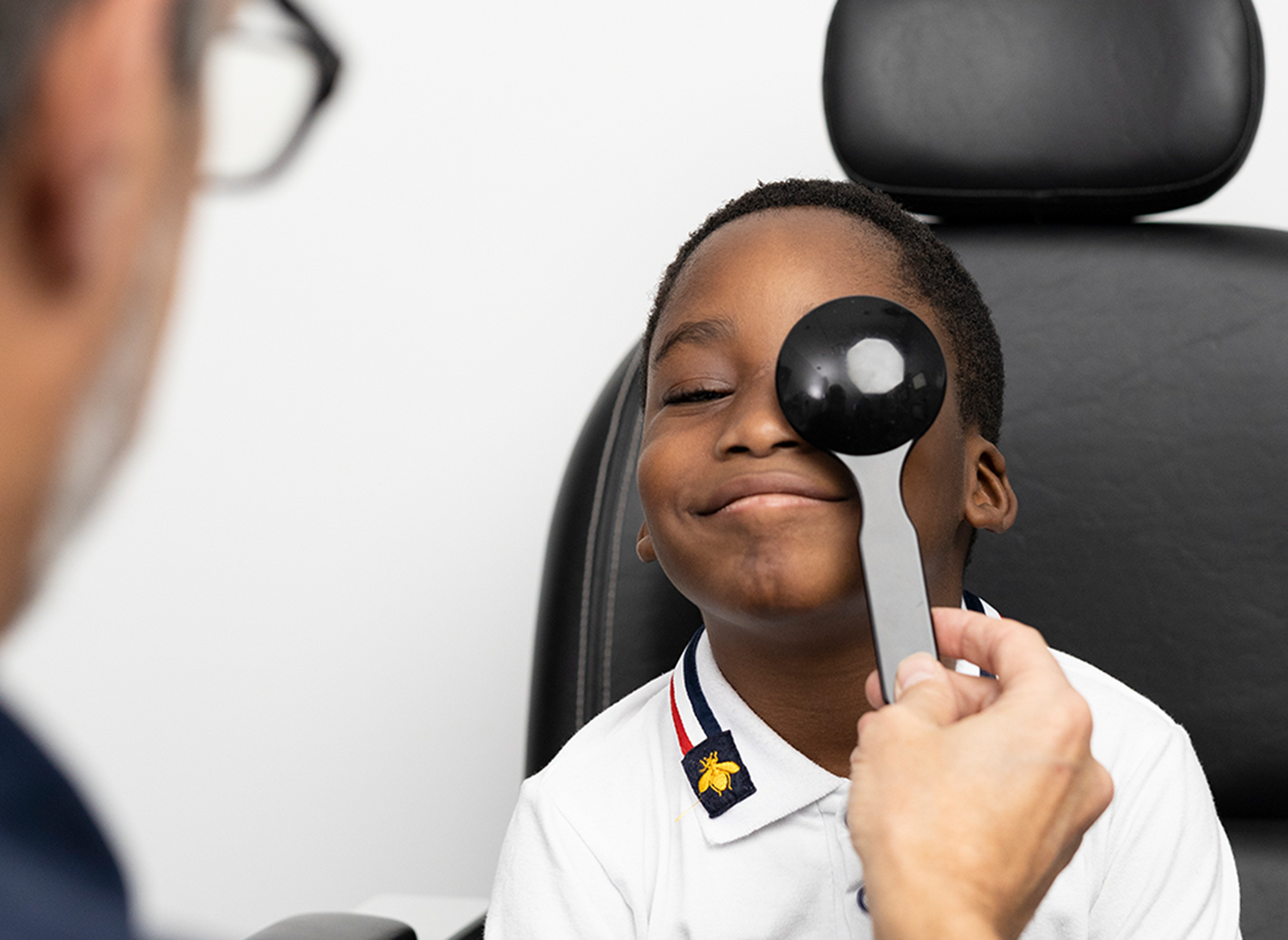 An Optometrist carrying out eye exam on a kid