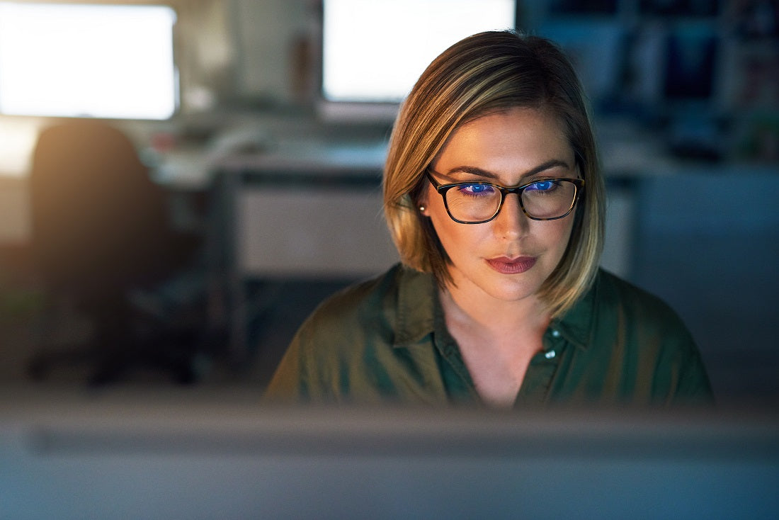 A woman with well coated glasses sitting in front of a computer
