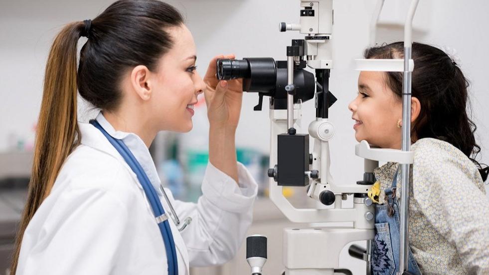 An optometrist conducting eye test for a kid using the latest eye technology. 