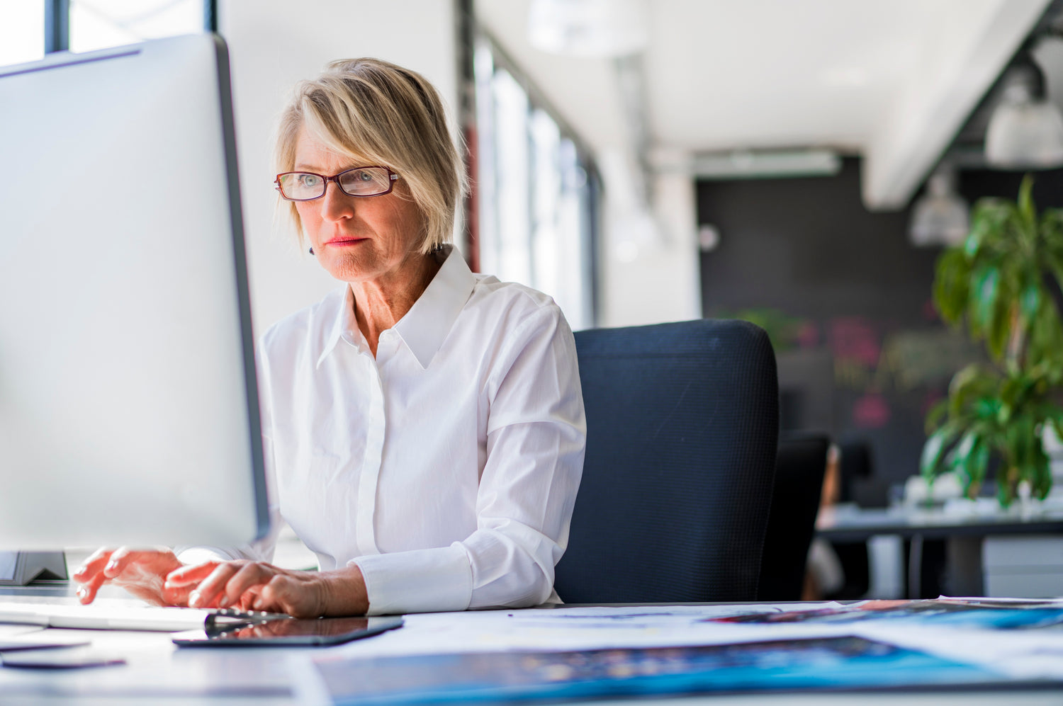 Professional lady in front of a computer with her specialty lens