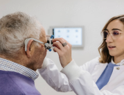An optometrist using technology to detect vision issues in a senior